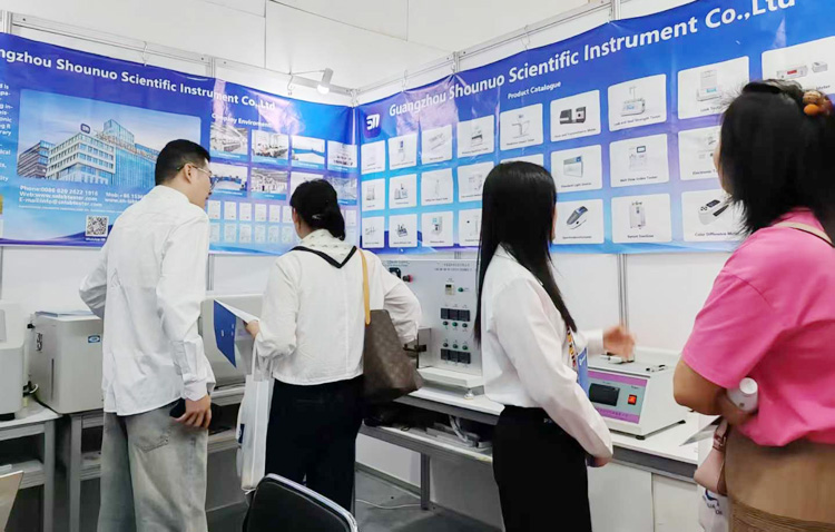 Staff members introducing packaging testing instruments to attendees.